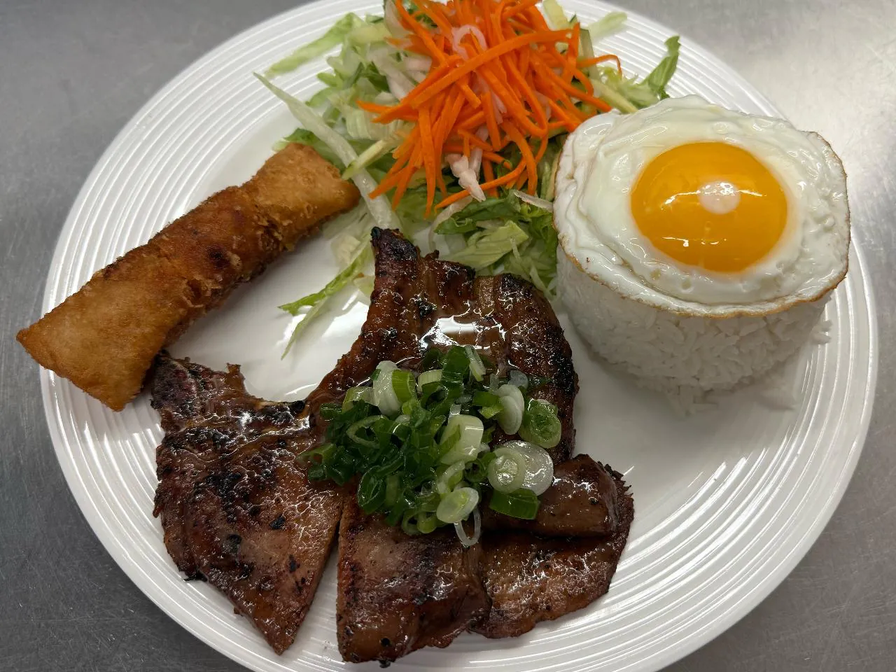 Rice Combo Rice plate with grilled pork, egg, and spring roll at An Chi, a Vietnamese restaurant in San Francisco